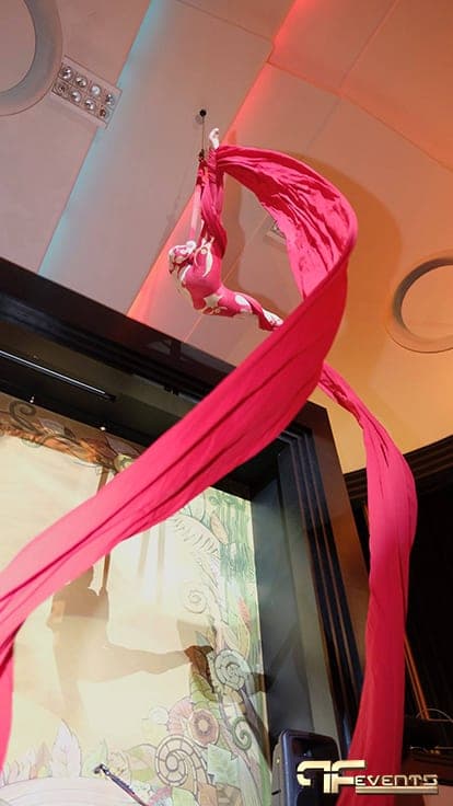 Aerial silk performer in pink high above the Eglinton Grand stage