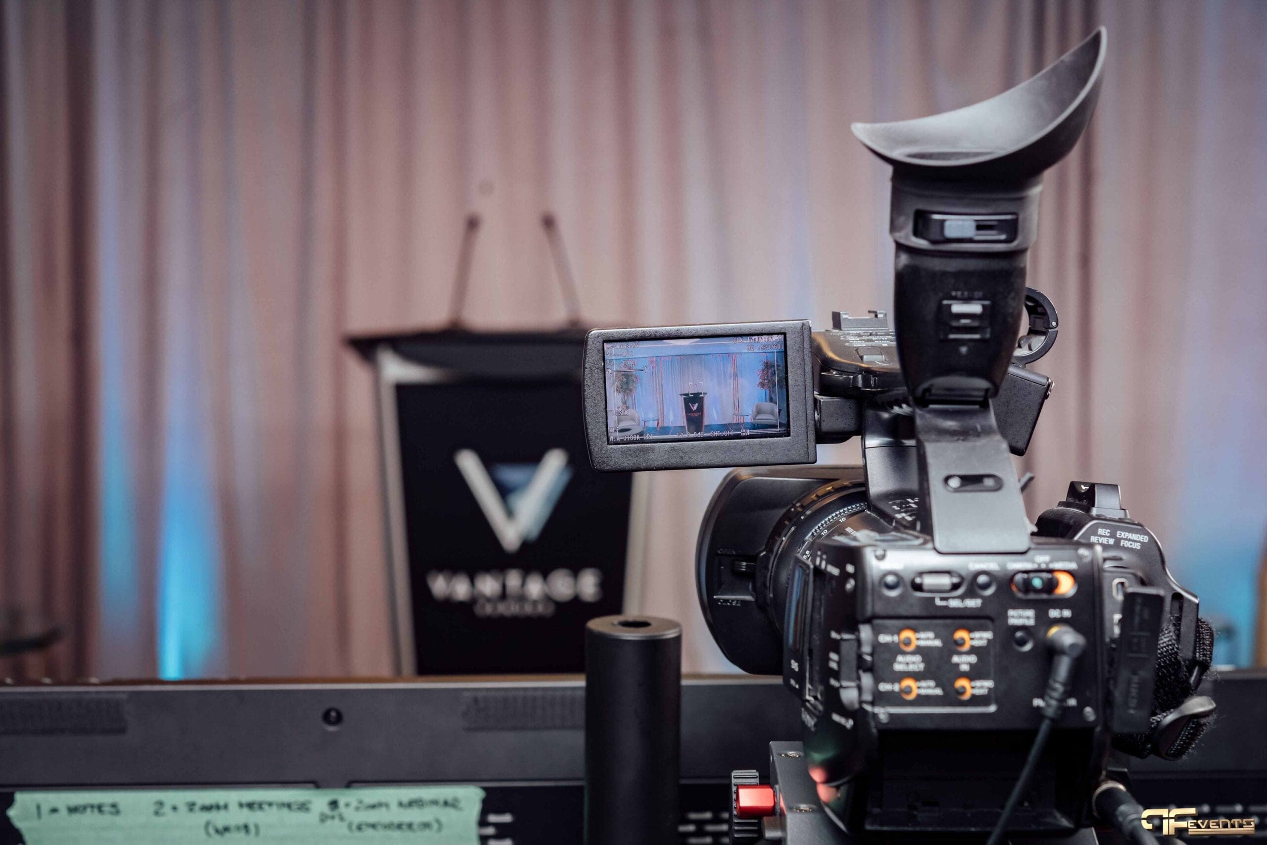 Camcorder framing the Vantage Venues podium, the stage on its flip screen