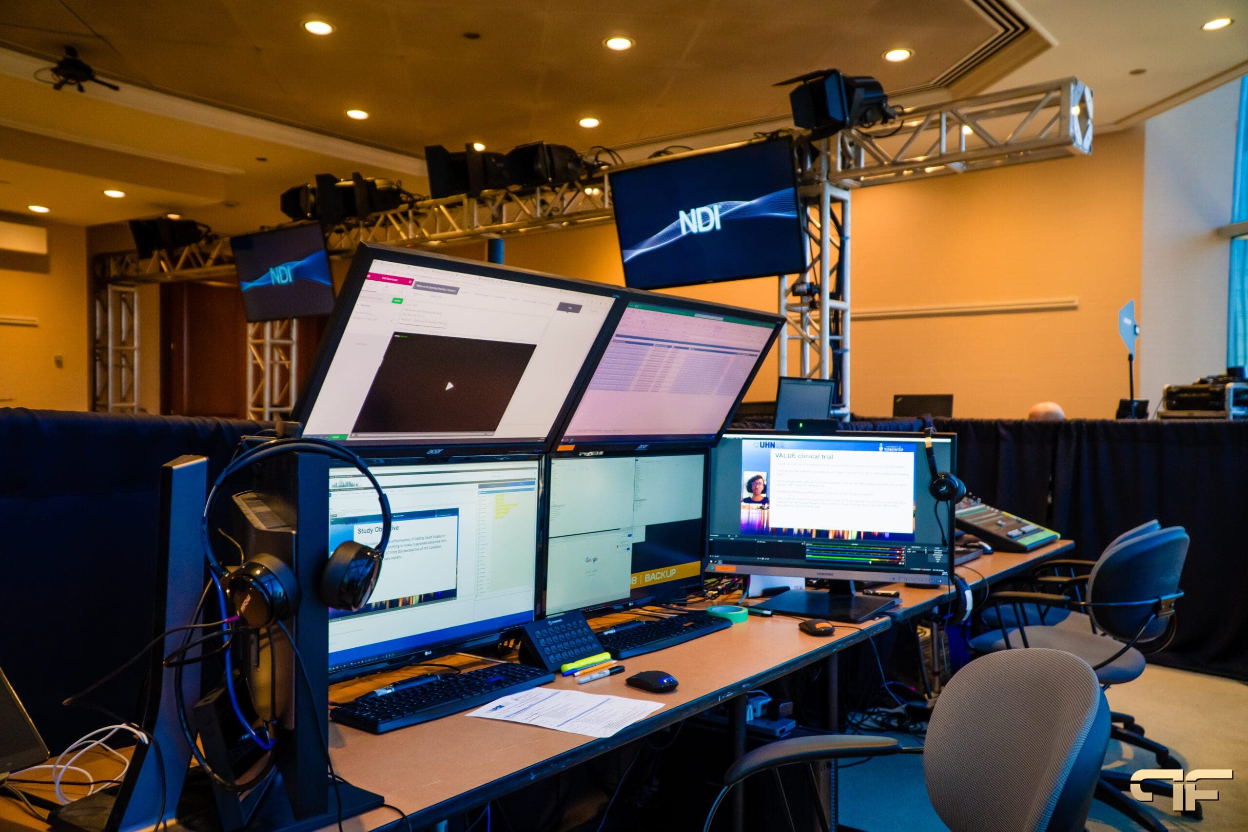 Hybrid control desk with multiple monitors under truss-mounted NDI screens